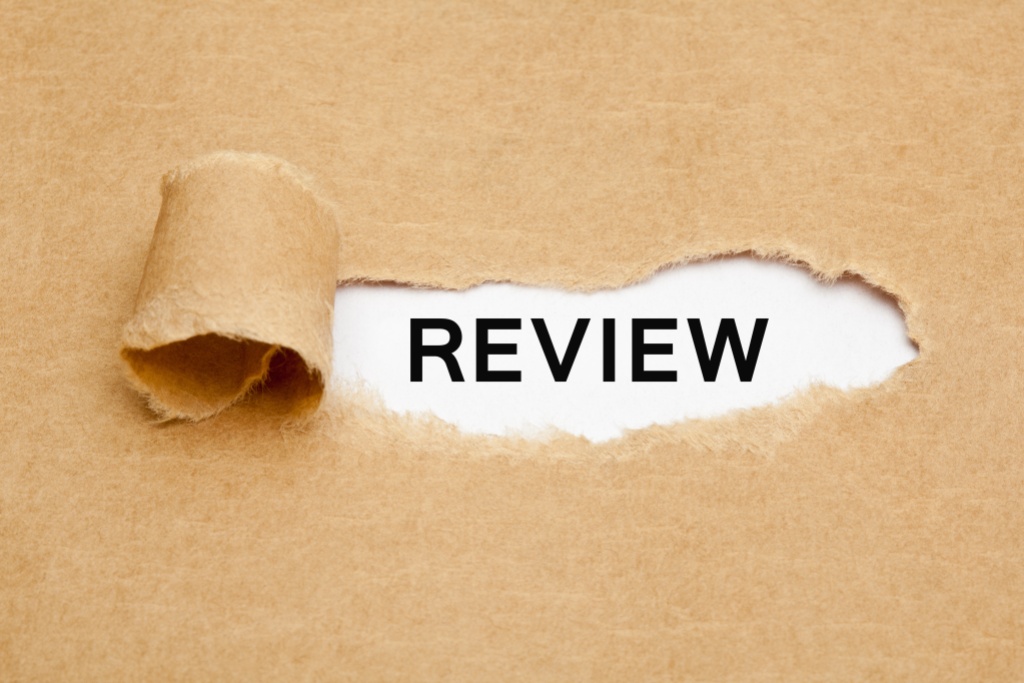The word Review appearing behind torn brown paper.